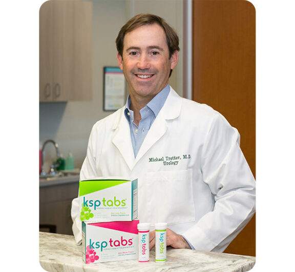 Man in a white lab coat with ksptabs products on a counter